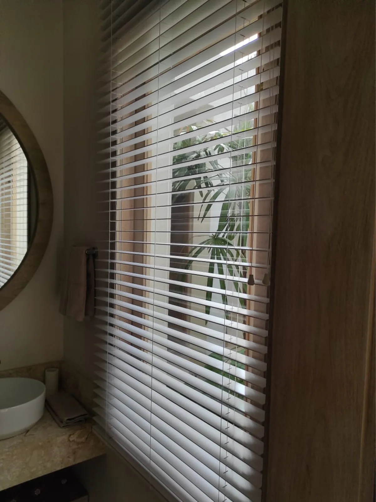 Bano con cortina veneciana de pvc abierta y vista al jardin