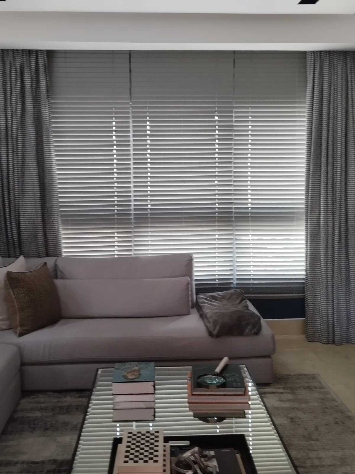 Sala con cortinas venecianas de aluminio y cortinas tachonadas
