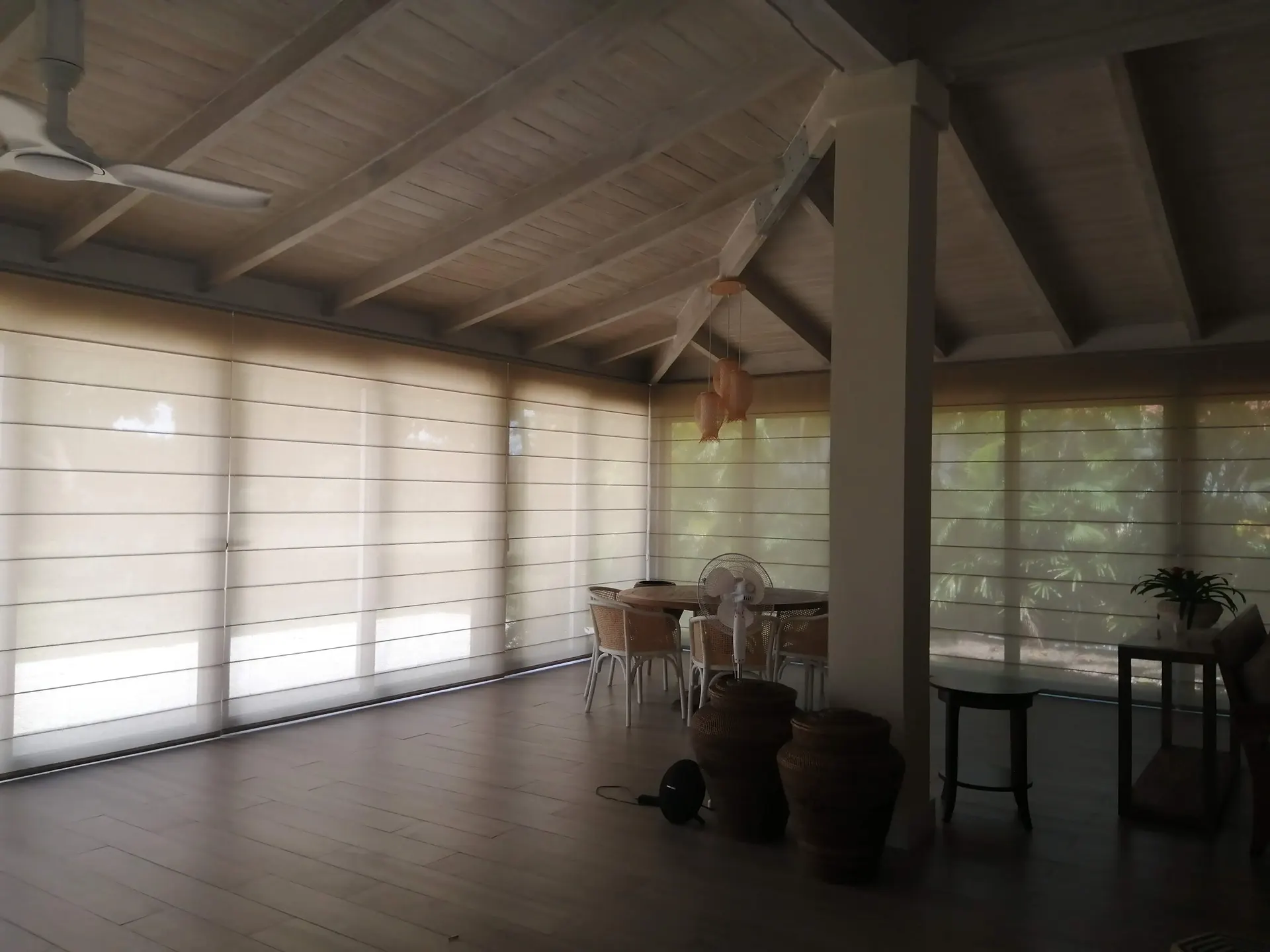 Instalación de cortinas romanas en salón con ventanales en Santo Domingo