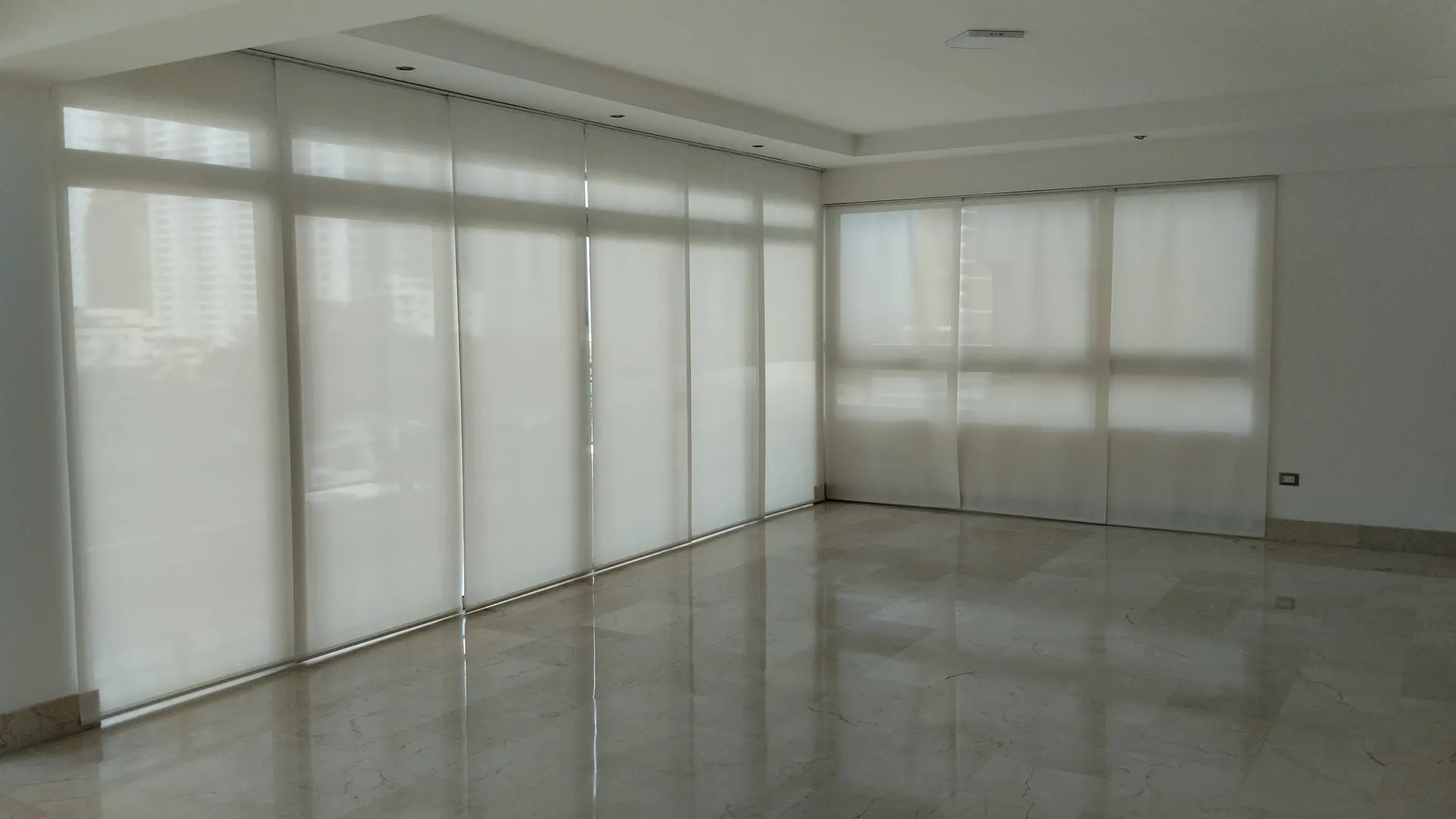 Instalación de panel deslizante en sala con ventanales en Santo Domingo