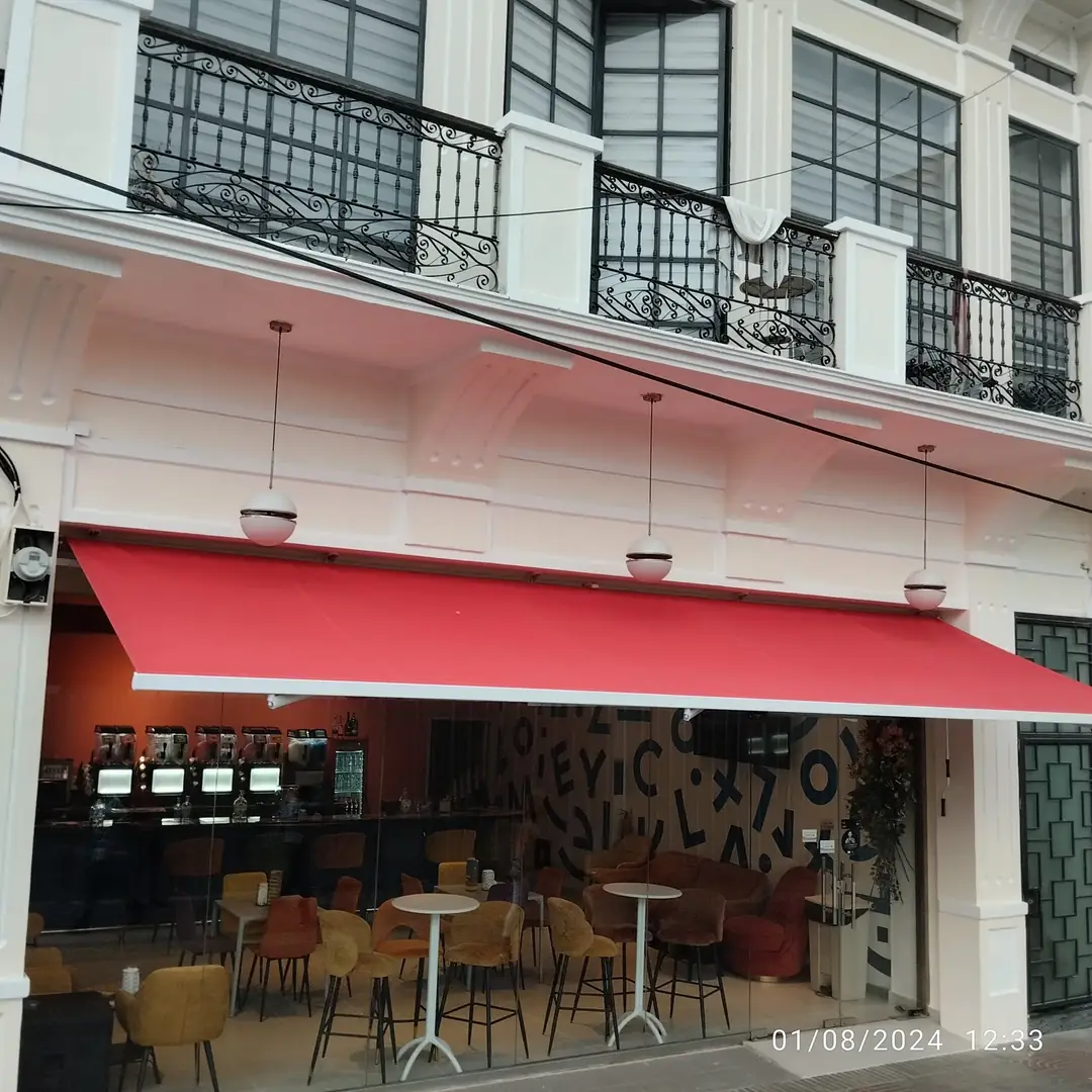 Instalación de toldo retráctil con tela de lona roja por Blinds Company en la Zona Colonial, Santo Domingo