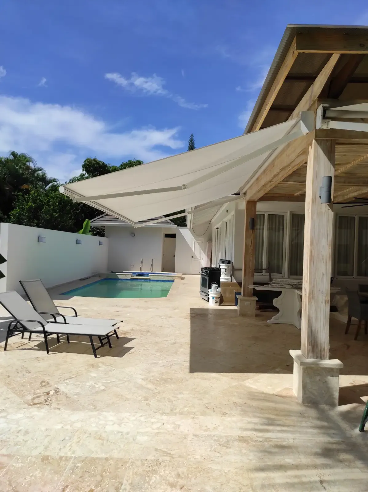 Instalación de toldo retráctil en terraza con piscina realizada por Blinds Company