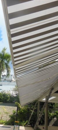 toldo-retractil-de-dos-colores-instalados-sobre-una-piscina